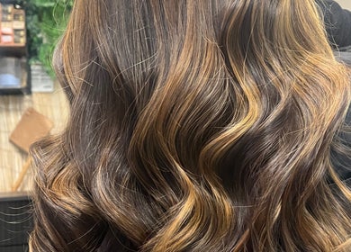 Elegant wavy brown hair with golden highlights at KG Hair, Newport, Wales, GB.