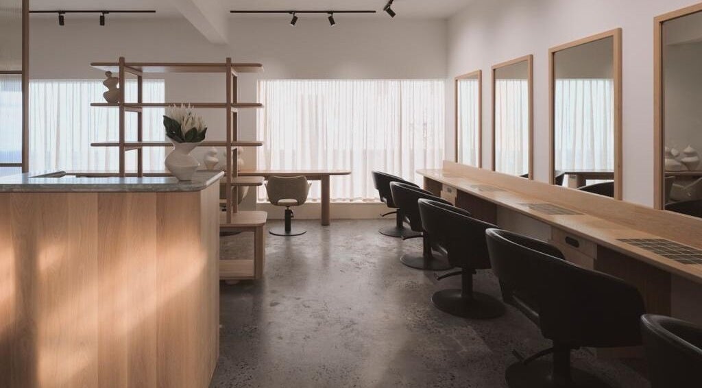Stylish interior of Papillon Hair at Avalon Beach, New South Wales, AU, featuring sleek chairs and modern decor.