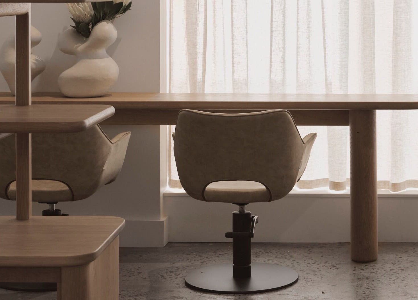 Elegant salon chairs and wooden table at Papillon Hair, Avalon Beach, New South Wales, AU.