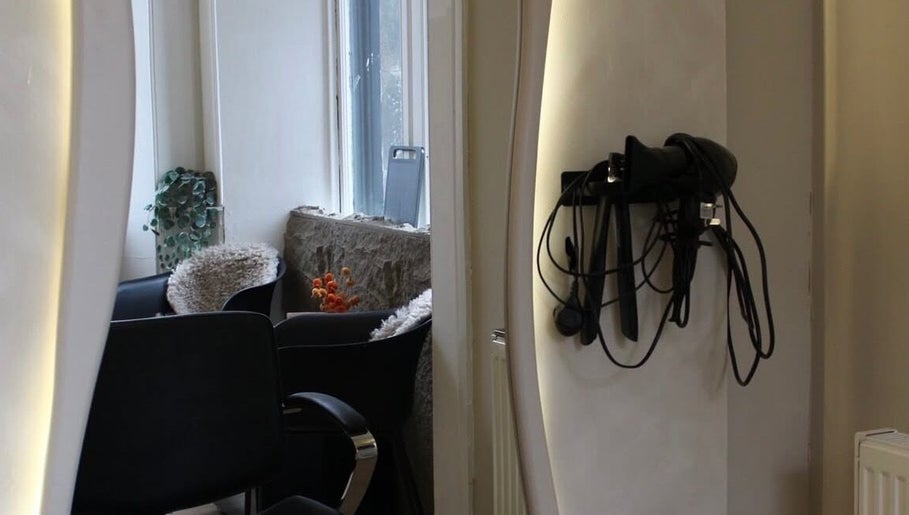 Cozy corner at Emily Louisa Hair, East Kilbride, Scotland, GB with styling tools and plush seating.