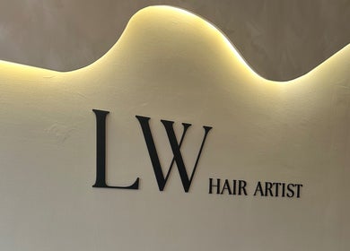 Modern wall signage of Emily Louisa Hair, East Kilbride, Scotland, GB with elegant lighting.