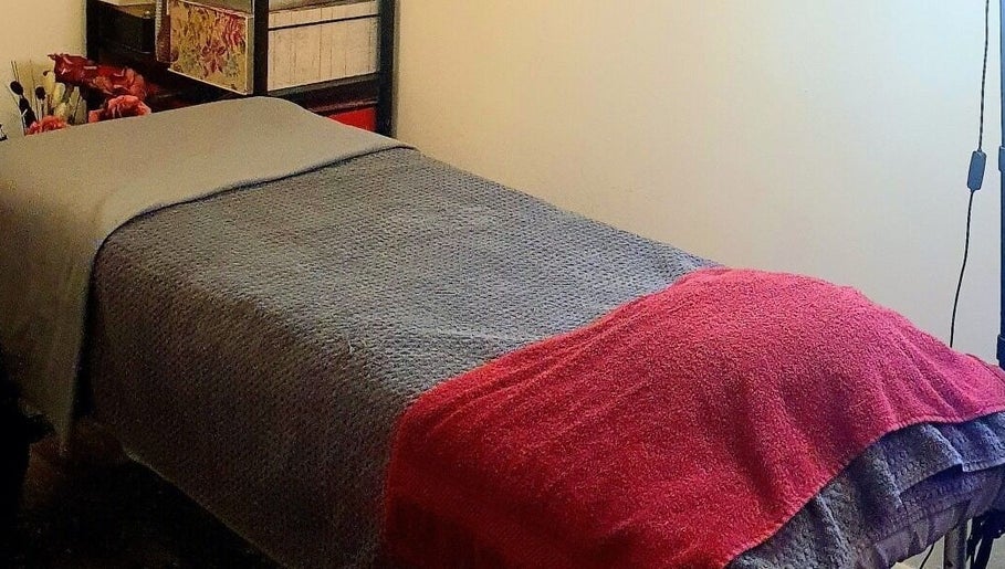 Cozy treatment room at Pupa Beauty Body Treatments in Weeting, England, GB with neatly arranged bed.