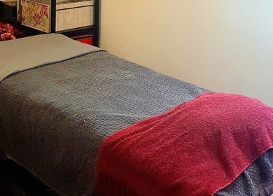 Cozy treatment room at Pupa Beauty Body Treatments in Weeting, England, GB with neatly arranged bed.