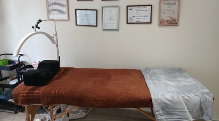 A well-prepared massage table at SN BEAUTY LAB, Johannesburg, Gauteng, ZA, with certificates on the wall.
