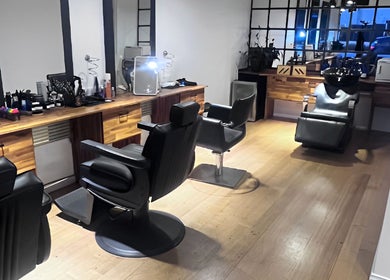 Modern interior of Be The Man Barber in Melbourne, Victoria, AU, showcasing sleek chairs and stylish decor.