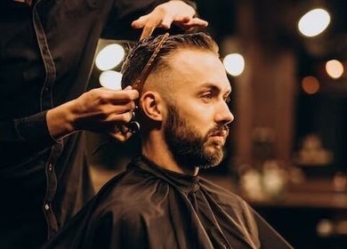 Barber styling a client's hair at Be The Man Barber in Melbourne, Victoria, AU. Modern interior with warm lighting.