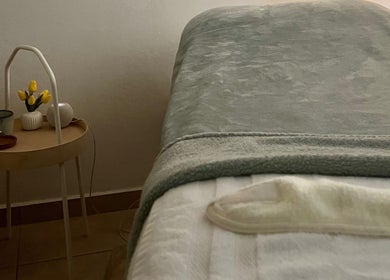 Relaxing treatment room at Valórate Aesthetic in Gurabo, Gurabo, PR, featuring a softly-lit table and tulips.
