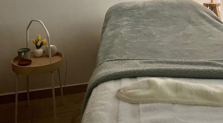 Relaxing treatment room at Valórate Aesthetic in Gurabo, Gurabo, PR, featuring a softly-lit table and tulips.