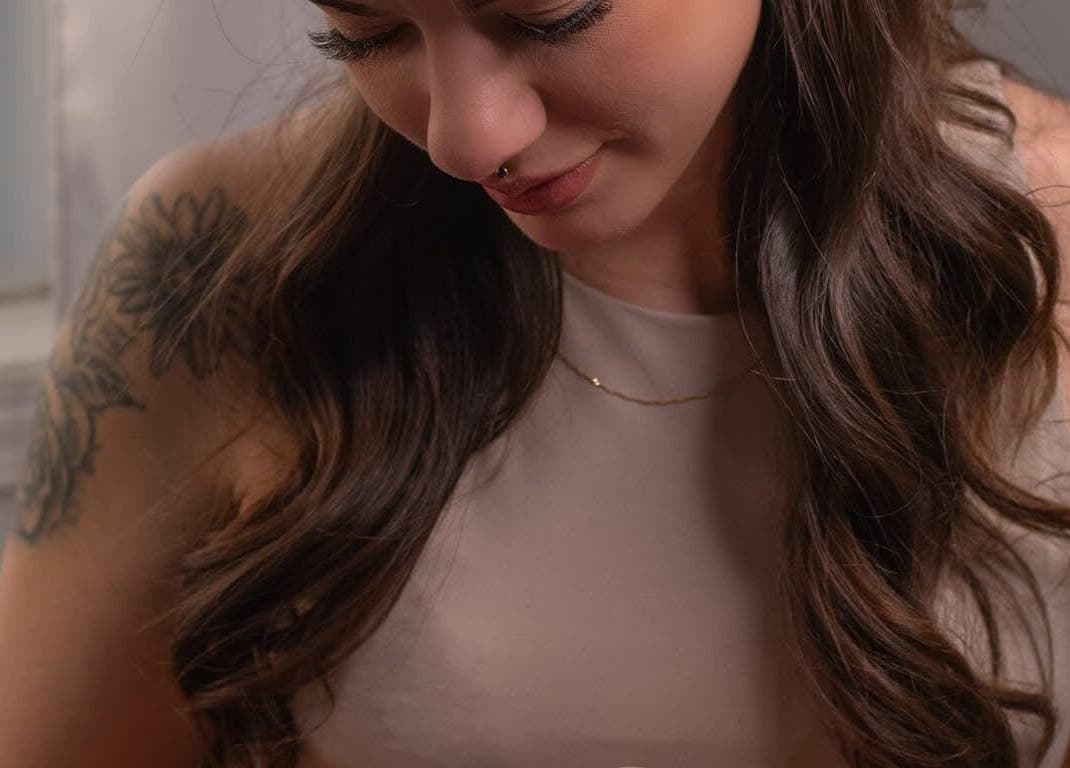 Femme élégante à By Clarose, Chambly, Québec, CA avec tatouage et cheveux bouclés.