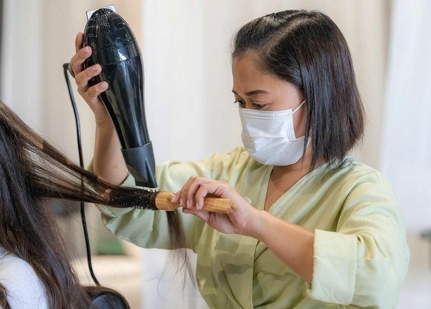 Professional stylist blow-drying hair at Dry by Spa, Riyadh, SA for a sleek look.