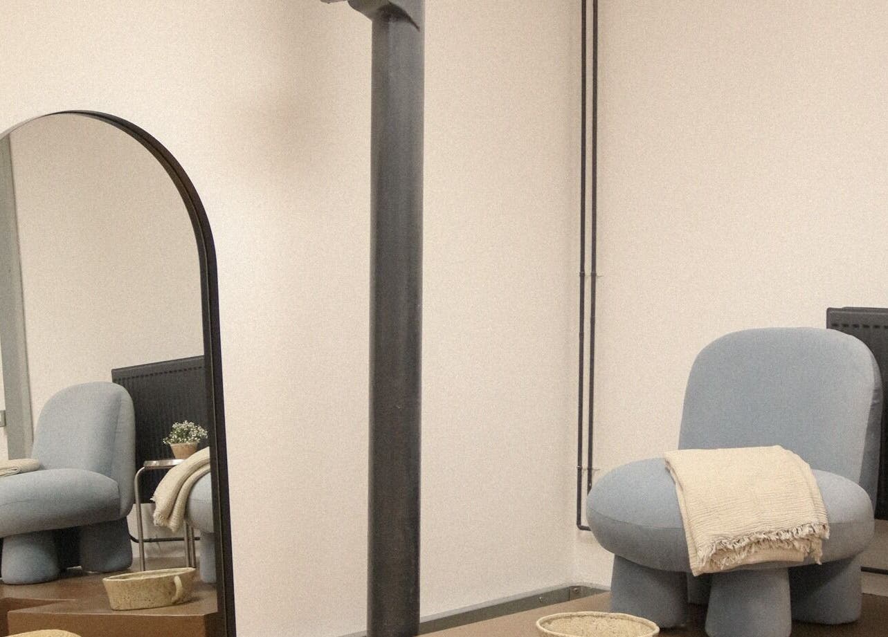 Modern lounge chair and mirror at Set Studio, Manchester, GB. Cozy and minimalist wellness space.