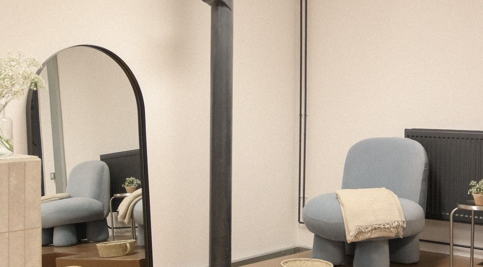 Modern lounge chair and mirror at Set Studio, Manchester, GB. Cozy and minimalist wellness space.