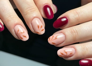 Close-up of elegant nail art at Haus of Rayah, Prestwich, England, GB featuring burgundy and leaf designs.