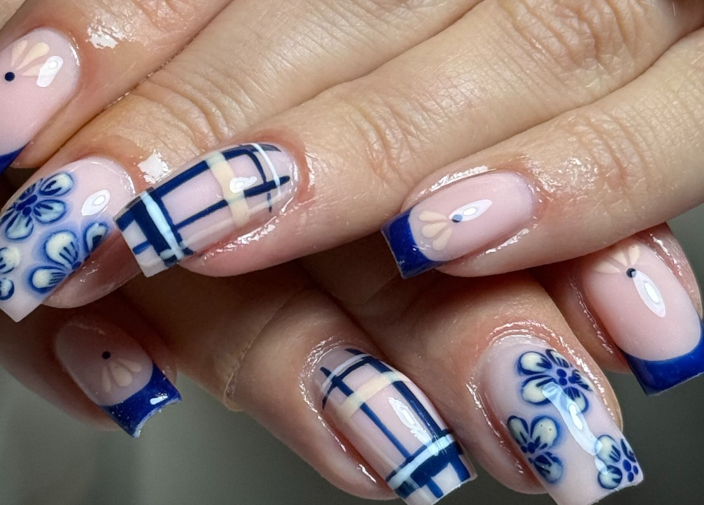 Elegant blue floral nail art at Haus of Rayah in Manchester, England, GB. Perfectly manicured nails showcase intricate design.