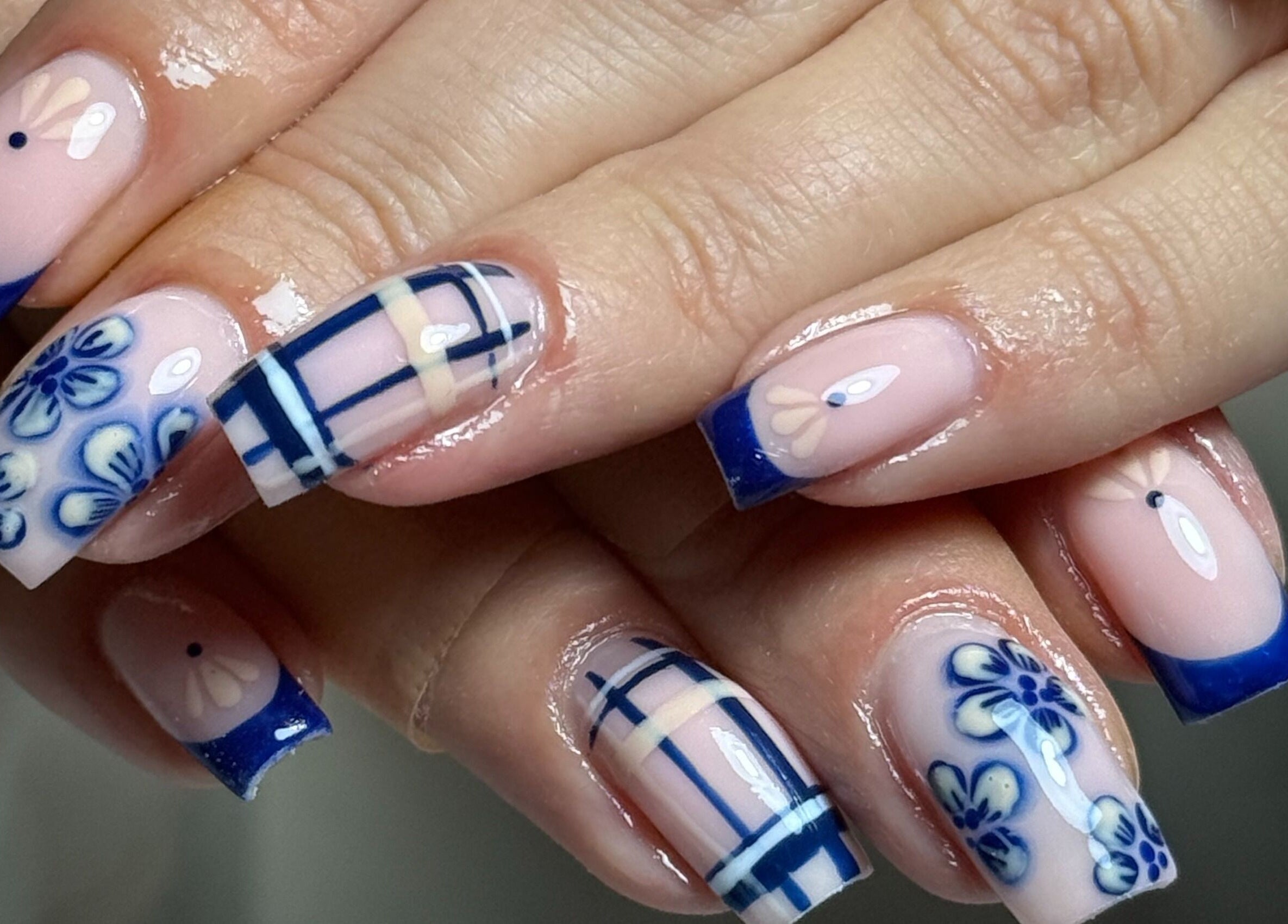 Elegant blue floral nail art at Haus of Rayah in Manchester, England, GB. Perfectly manicured nails showcase intricate design.