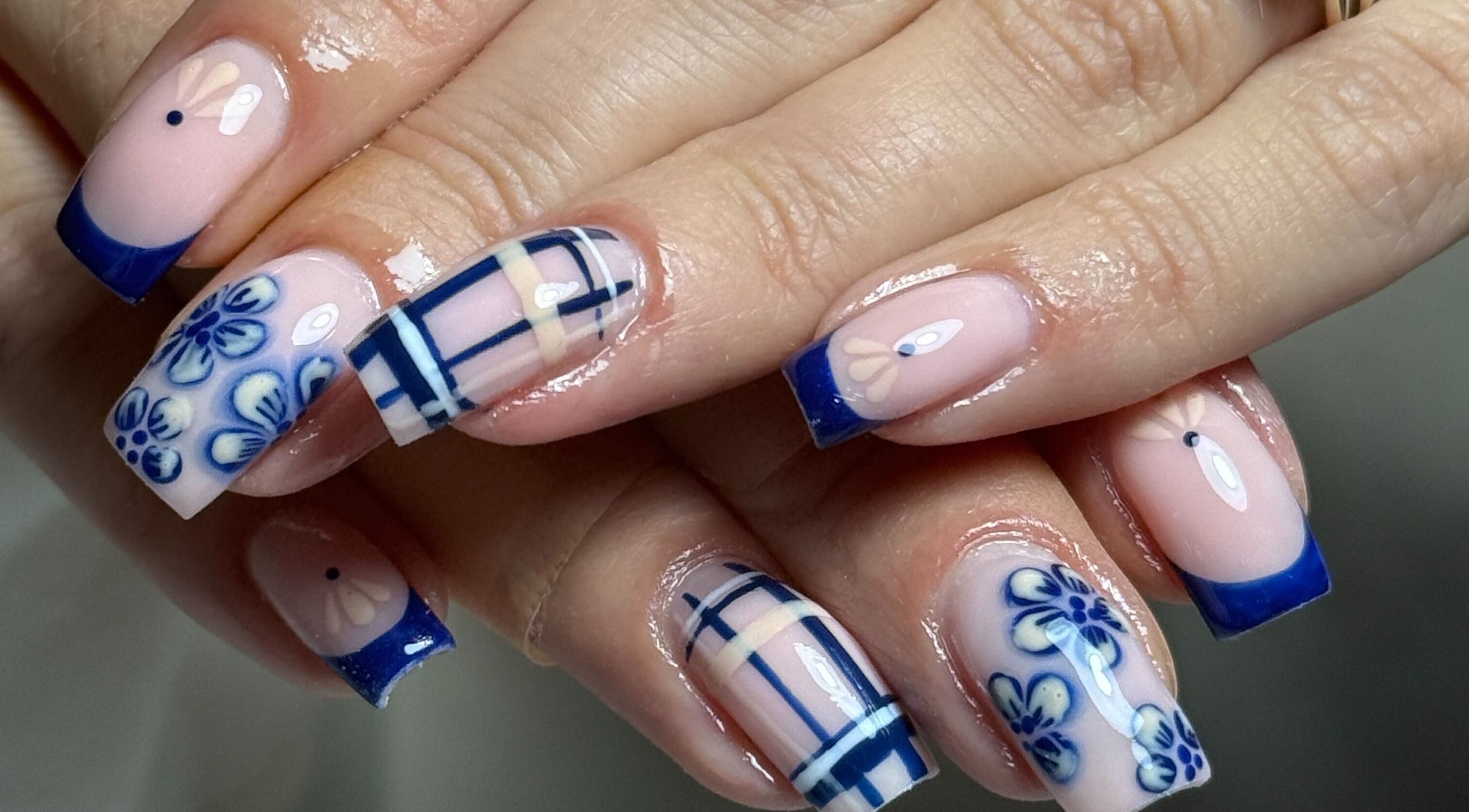 Elegant blue floral nail art at Haus of Rayah in Manchester, England, GB. Perfectly manicured nails showcase intricate design.