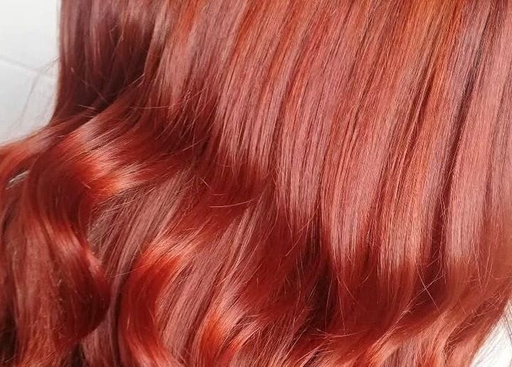 Vibrant red hair styled with soft waves at Taryn Lee Hairdressing, Johannesburg, Gauteng, ZA.