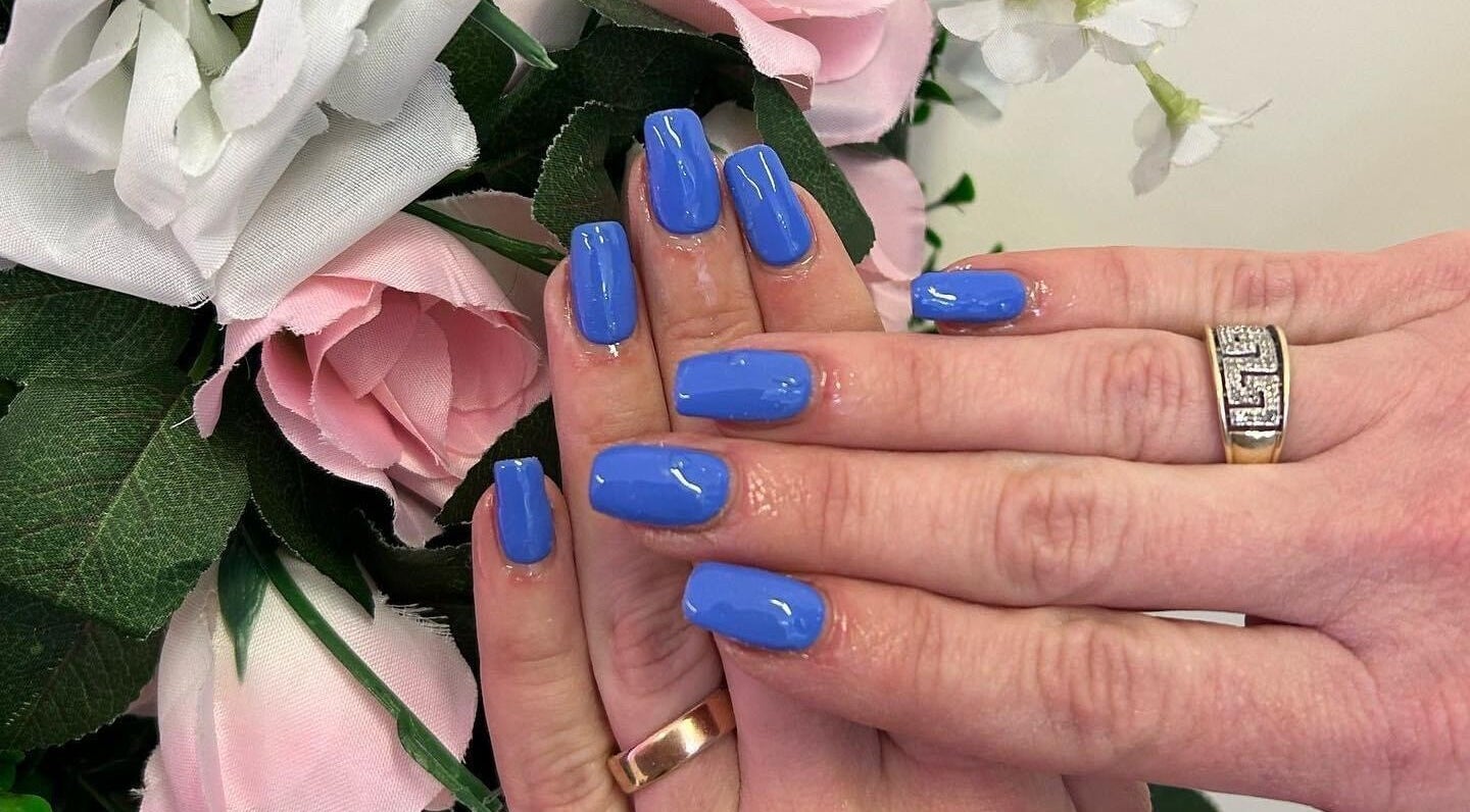 Elegant blue manicured nails with floral backdrop at Jessica Jay Salon, Perth, Scotland, GB.