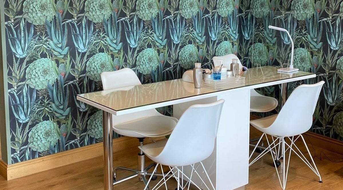 Stylish manicure station at Oasis Beauty Clinic in Portadown, Northern Ireland, GB with green floral wallpaper.
