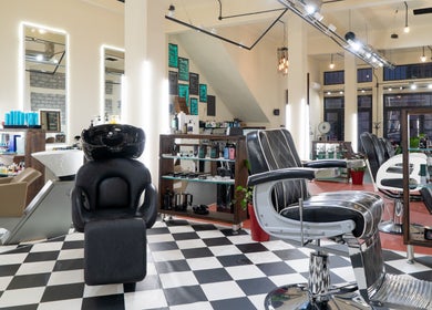 Κομψό εσωτερικό του Koureio Barbershop στην Ιεράπετρα, GR με καρέκλες και προϊόντα περιποίησης.