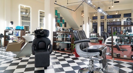 Κομψό εσωτερικό του Koureio Barbershop στην Ιεράπετρα, GR με καρέκλες και προϊόντα περιποίησης.