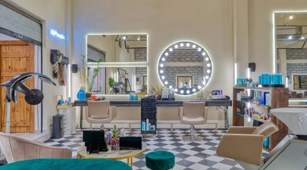 Εσωτερικό κομμωτηρίου Koureio Barbershop στην Ιεράπετρα, GR με μοντέρνα αισθητική και φωτεινούς καθρέφτες.