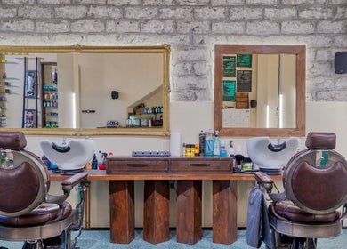 Εσωτερικό του Koureio Barbershop με κομψές καρέκλες και καθρέφτες στην Ιεράπετρα, GR.
