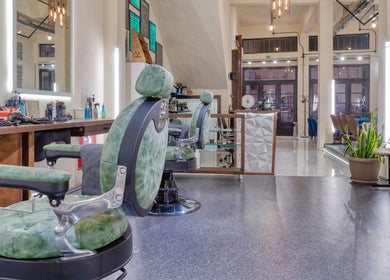 Εσωτερικό του Koureio Barbershop στην Ιεράπετρα, GR με σύγχρονη διακόσμηση και καθίσματα.