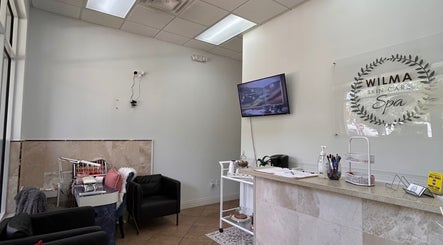 Interior of Wilma Skin Care in Coconut Creek, Florida, US, featuring a cozy seating area and a modern reception desk.