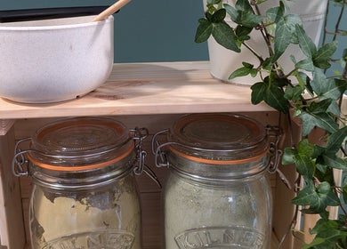 Herbal jars and plants on a wooden shelf at The Eco Green Salon, Ulverston, England, GB.