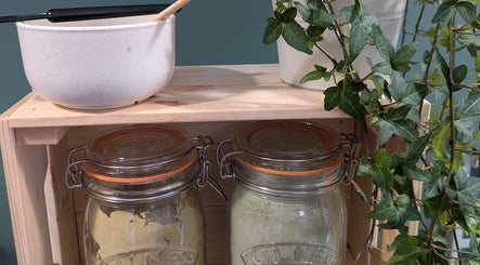 Herbal jars and plants on a wooden shelf at The Eco Green Salon, Ulverston, England, GB.