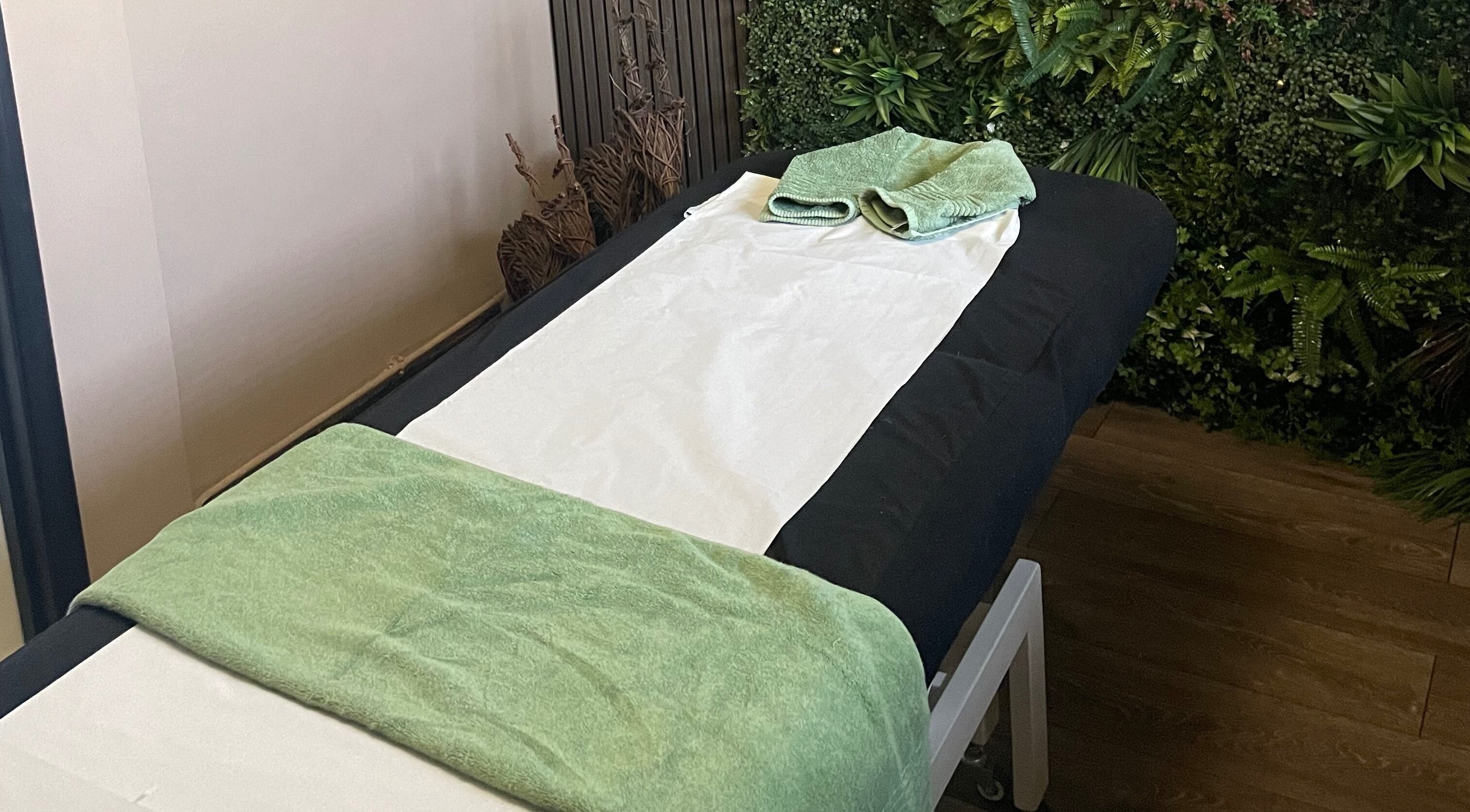 Calming therapy room setup at Flo Morris Sports Therapy, Newnham, England, GB with green towels and peaceful ambiance.