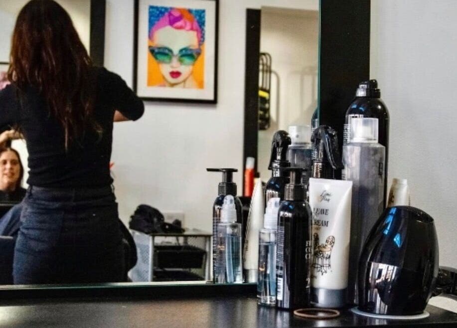 Stylist working at Zest Studio, Colchester, England, GB with hair products and decorative art.