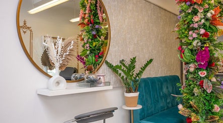 Elegant entry of Misha & Eti Beauty Studio in Manchester, England, GB with vibrant floral decor and plush seating.