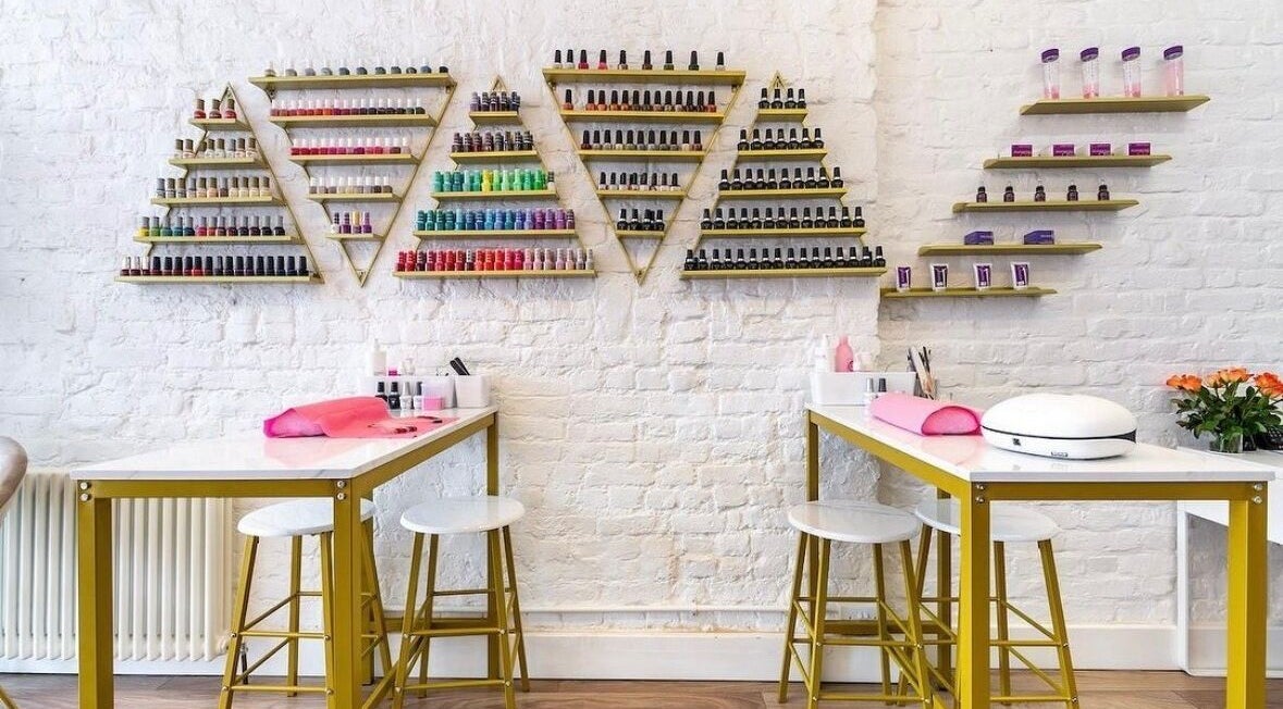 Modern nail care setup at Arta Beauty Clinic, showcasing vibrant polish display in London, England, GB.
