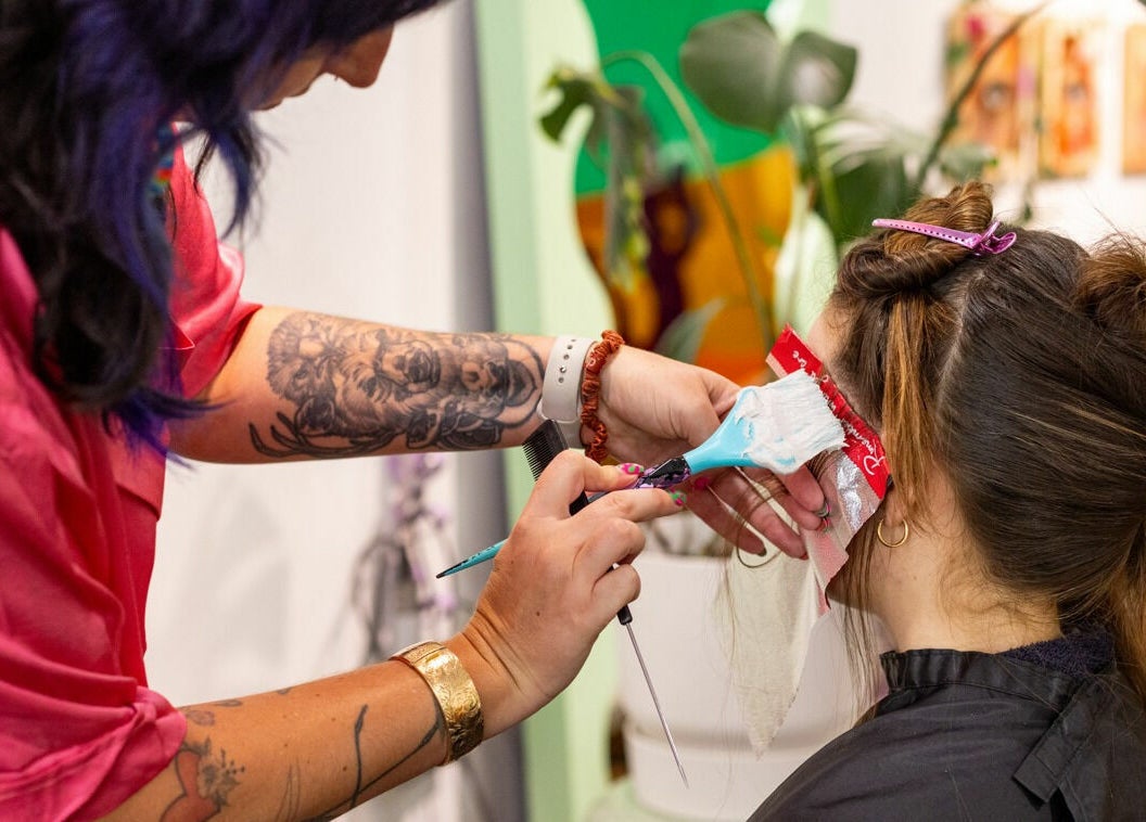 Professional hairstylist coloring client's hair at Dollie and Stella, Sydney, Australia, AU, with vibrant technique.
