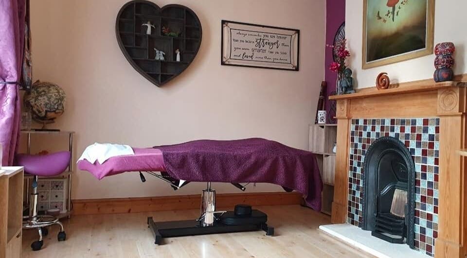 Cozy therapy room at Precision Therapy, Portsmouth, England, GB showcasing a massage table with purple decor.