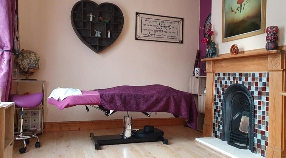 Cozy therapy room at Precision Therapy, Portsmouth, England, GB showcasing a massage table with purple decor.