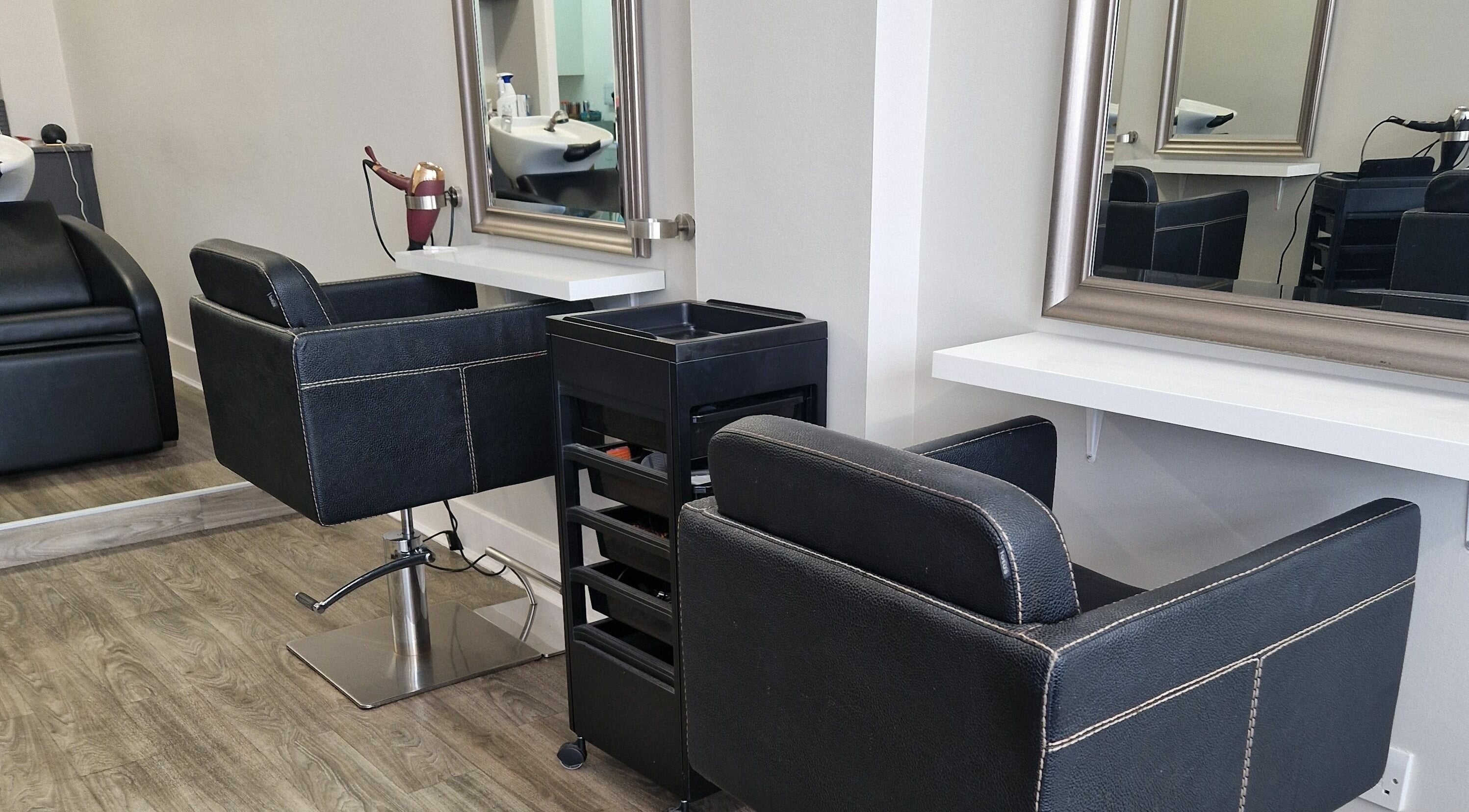 Keko Hair Design Wishaw salon styling stations in Wishaw, Scotland, GB with sleek black chairs and mirrors.