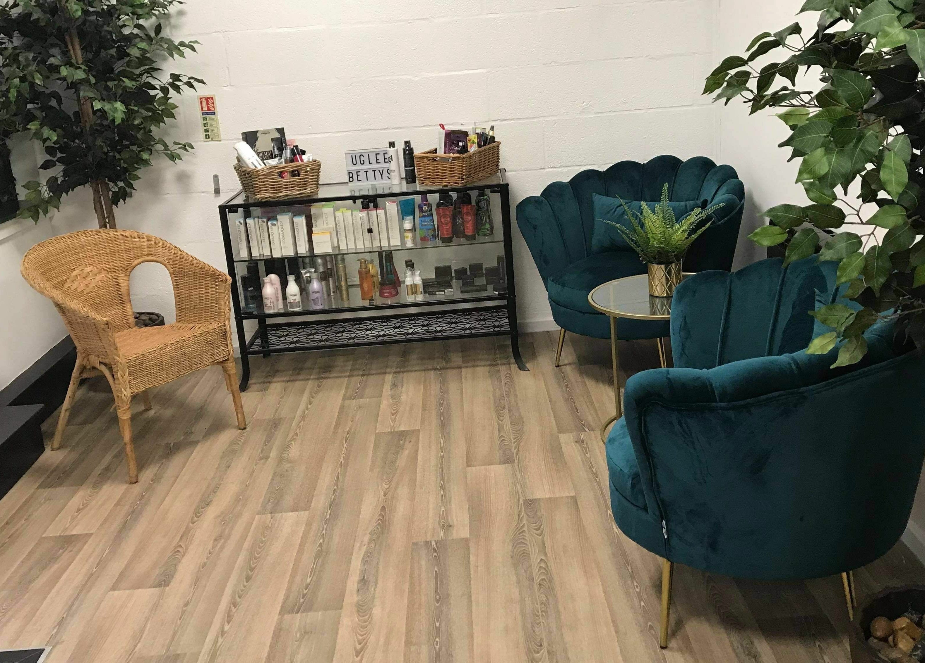 Chic waiting area at Uglee Betties, Carlisle, England, GB with plush chairs and product display.
