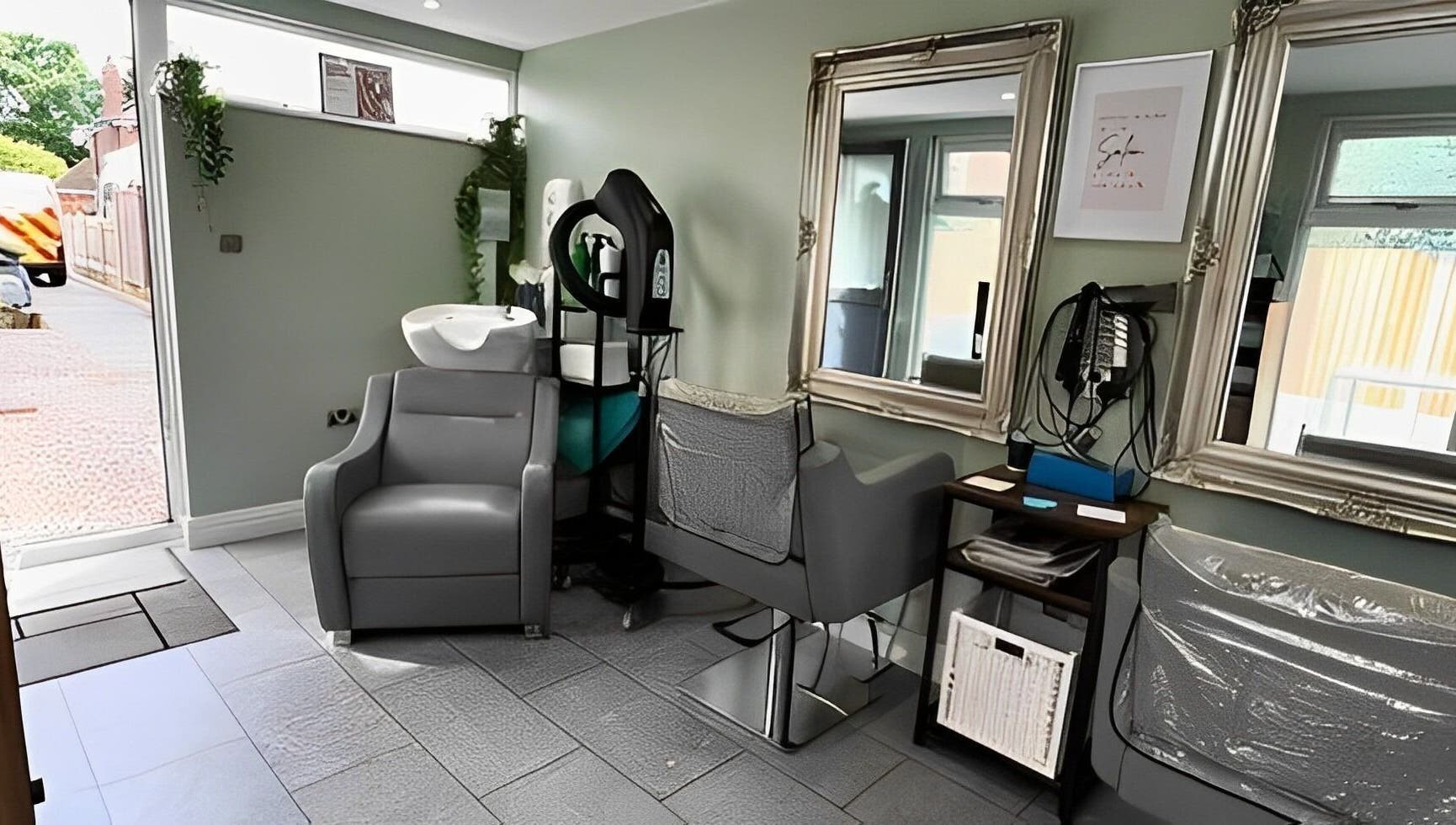 Modern salon station at Reflections by Cheryl in Stafford, England, GB featuring elegant mirrors and styling chairs.