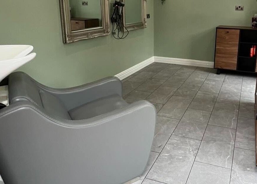 Modern salon interior at Reflections by Cheryl, Stafford, England, GB with grey chair and mirrors.