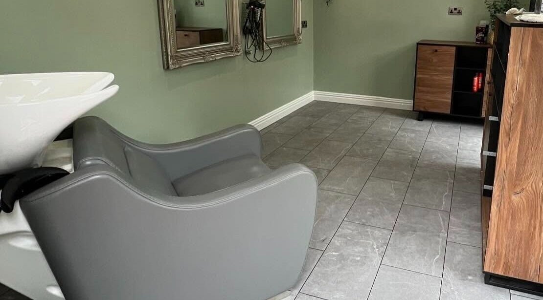 Modern salon interior at Reflections by Cheryl, Stafford, England, GB with grey chair and mirrors.