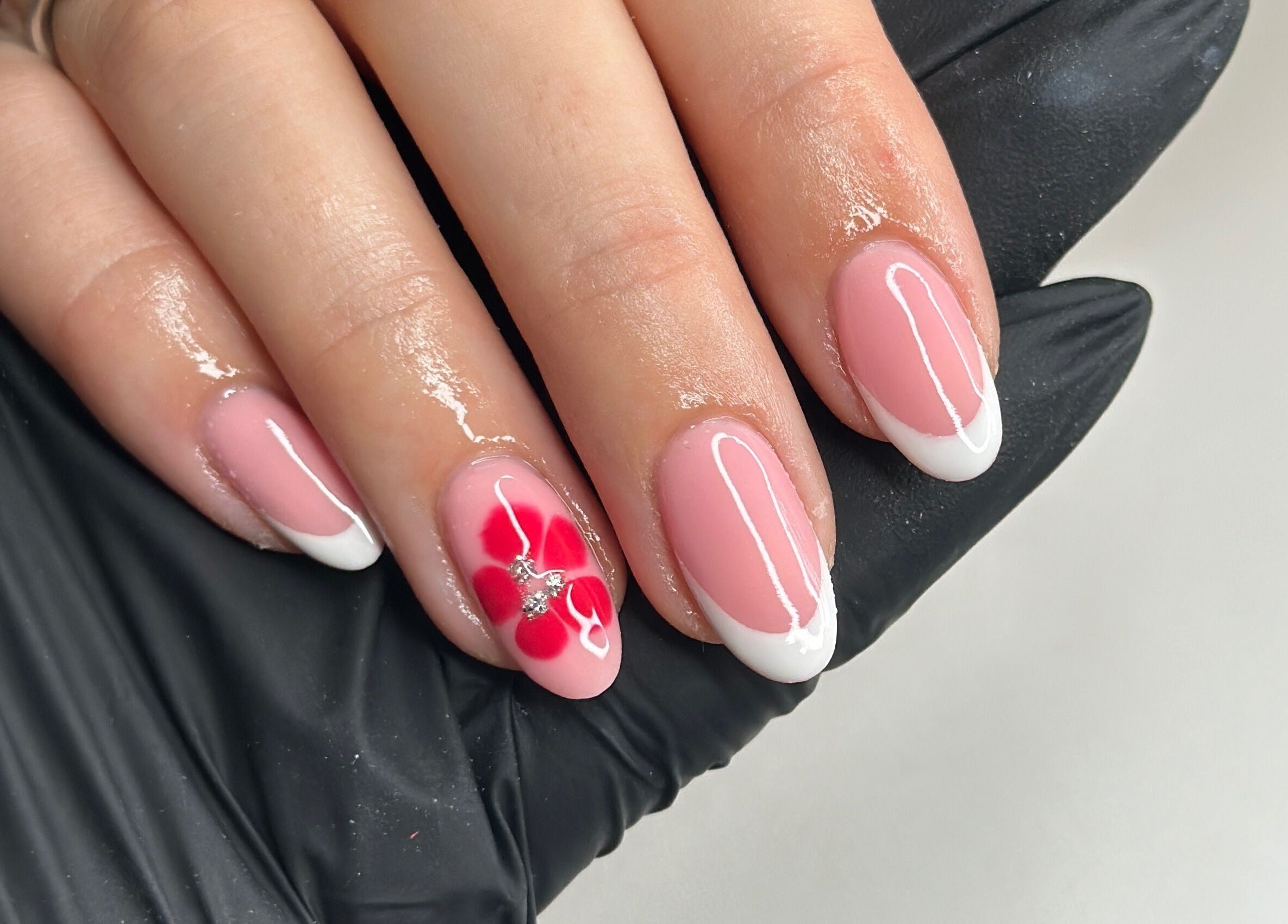 Beautiful floral nail design at Livin Beauty Lounge, Purton, England, GB. Pink and white manicure with red flower.