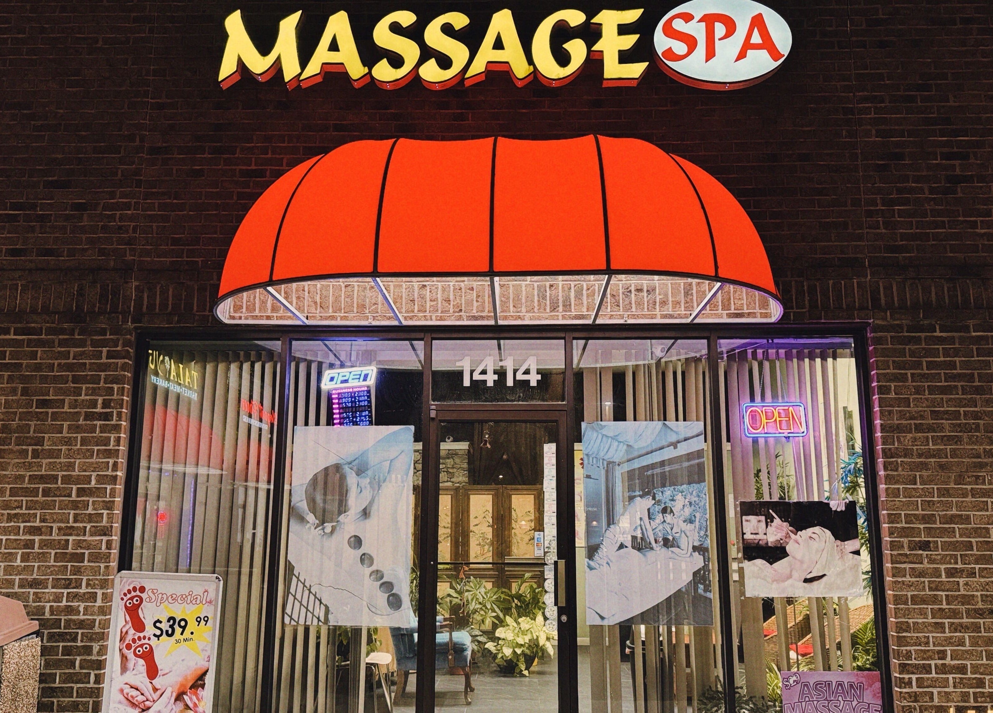 Front view of Asian Massage in Chesapeake, Virginia, US, with a bright red awning and glowing signage.