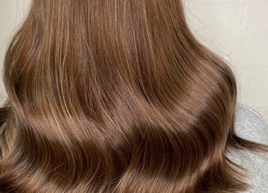Shiny brunette waves at Adele Howarth Hair, Glasgow, Scotland, GB showcasing expert hairstyling.