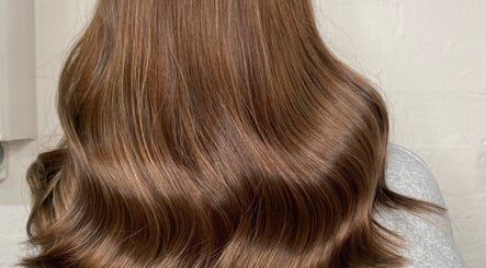 Shiny brunette waves at Adele Howarth Hair, Glasgow, Scotland, GB showcasing expert hairstyling.