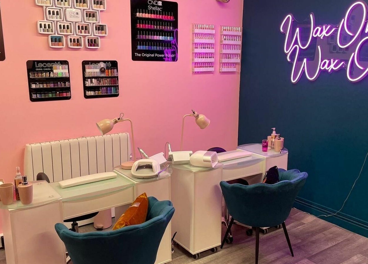 Modern nail salon at Gems Beauty in Swindon, England, GB with cozy chairs and vibrant wall decor.