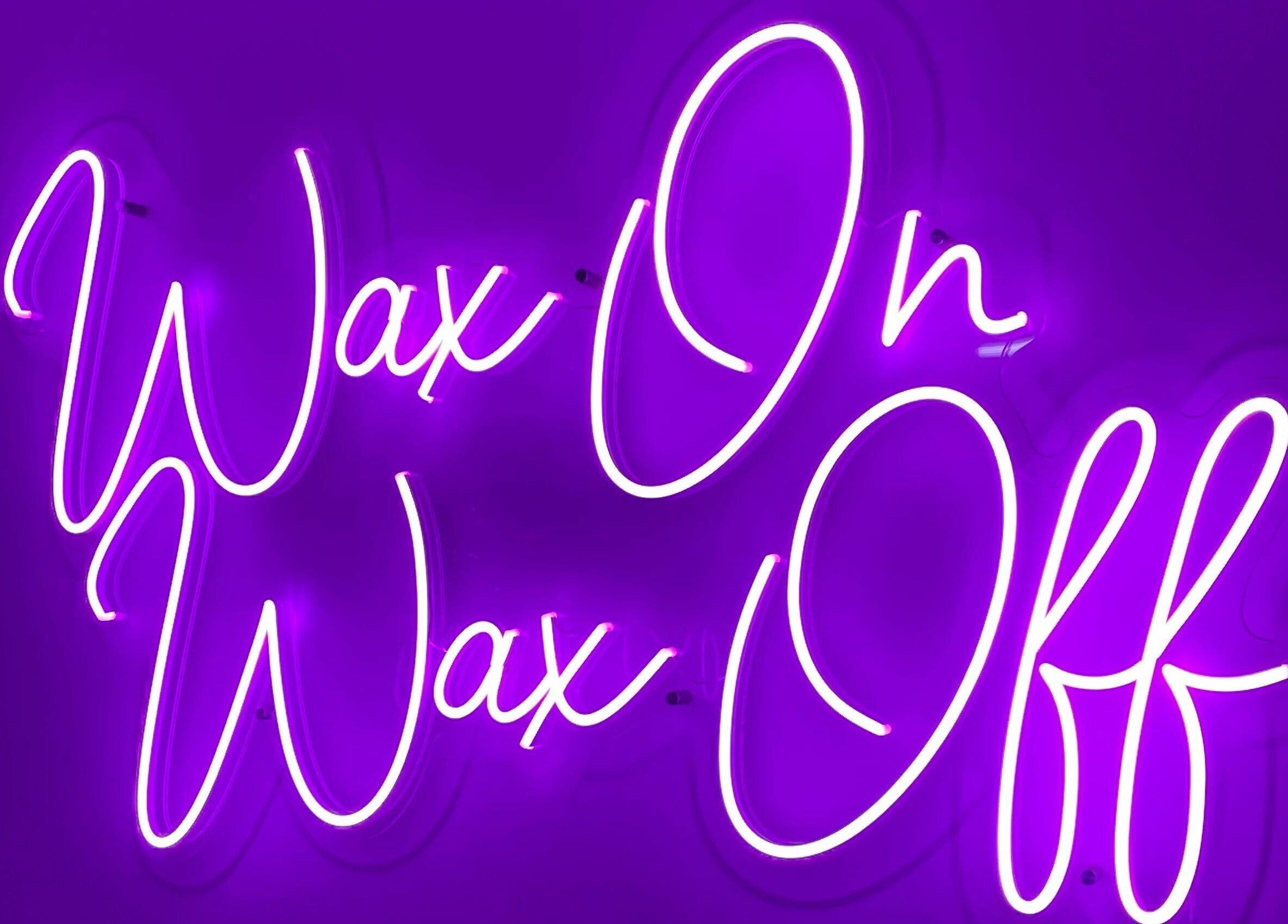 Vibrant neon sign saying 'Wax On Wax Off' at Gems Beauty, Swindon, England, GB.