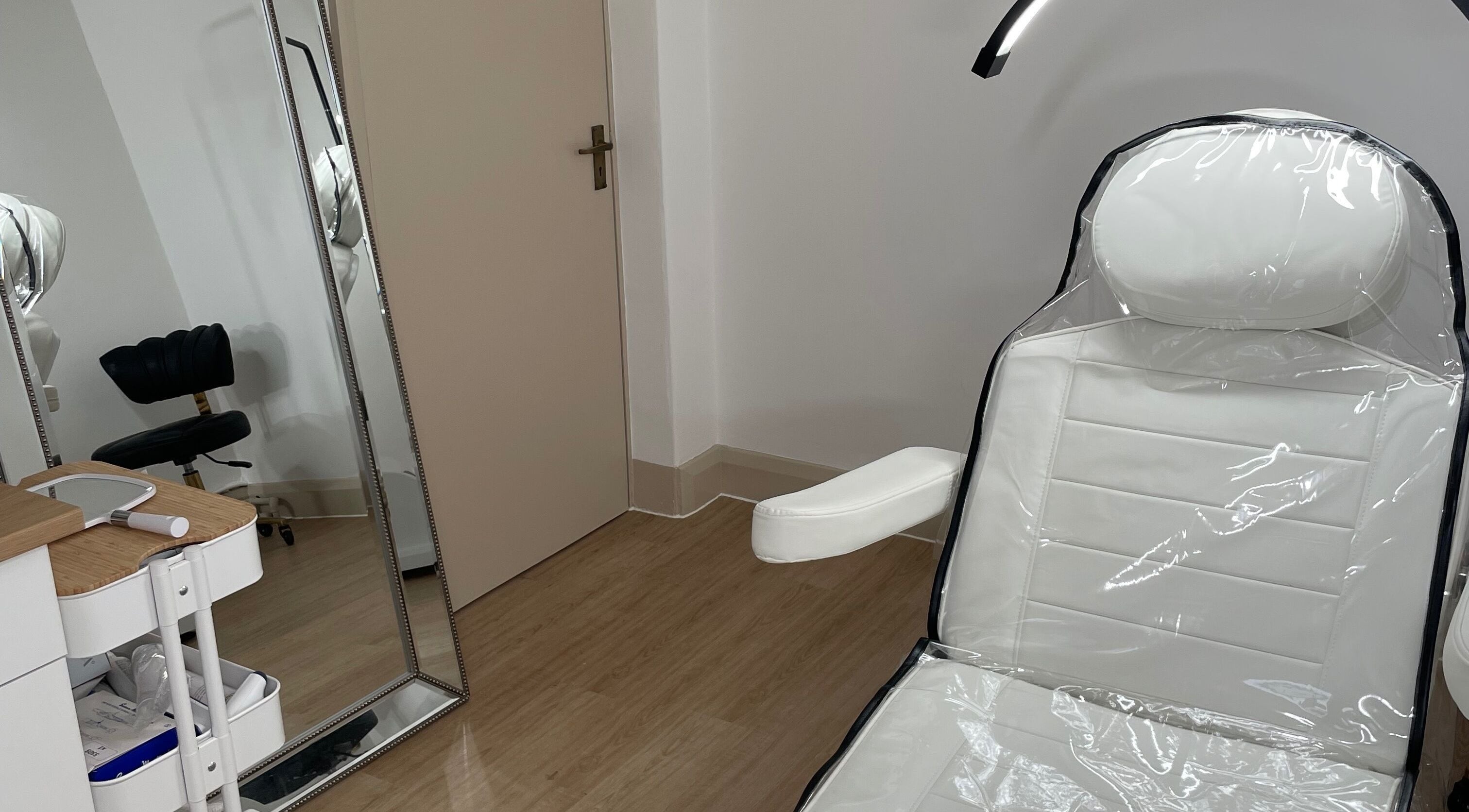 Calm treatment room at LR Skin & Aesthetics in Leicester, England, GB with white chair and mirror.